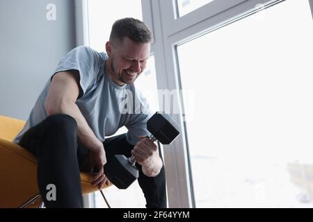 Man does exercises with dumbbells for biceps Stock Photo