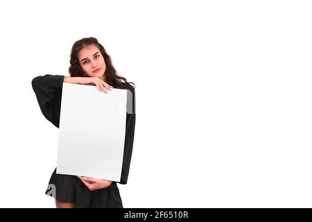 The woman shows an empty white large sheet of A3 paper. Presentation of the leaflet. free space Stock Photo