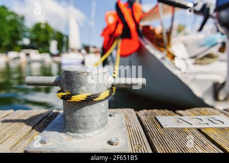 yacht moored with a line tied around a fixing on the quayside, mooring at a pier close up view Stock Photo