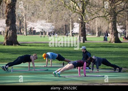 UK weather, London, 30 March 2021: In Battersea Park an outdoor exercise class adheres to the the rule of 6. Anna Watson/Alamy Live News Stock Photo