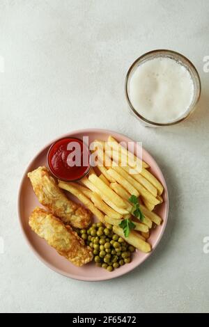 Plate with fried fish and chips, and beer on white textured table Stock Photo