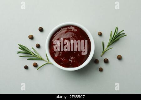 Bowl of barbecue sauce and spices on light gray background Stock Photo