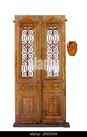 vintage wooden doors with wrought iron rusty grille and clay jug, bas-relief isolated on white background Stock Photo