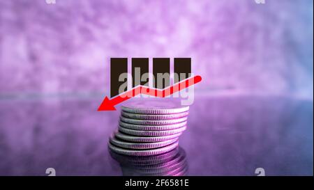 Down arrow on coins, economy concept Stock Photo