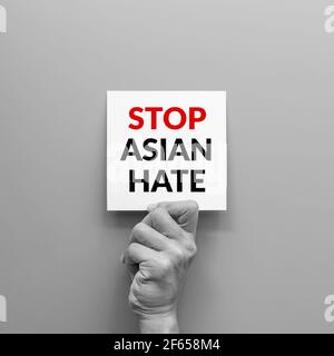 stop Asian hate concept. hand holding card paper sheet with word stop Asian hate for poster of campaign. Stock Photo