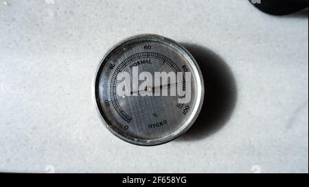 closeup to an analog hygrometer with high humidity on marble countertop Stock Photo