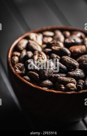 Roasted cocoa beans on black table. Stock Photo