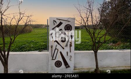 Old Power tools hanging on the white wall Stock Photo