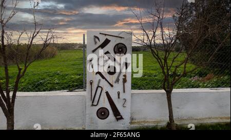 Old Power tools hanging on the white wall Stock Photo