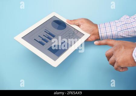 man's hand working on digital tablet against blue background  Stock Photo