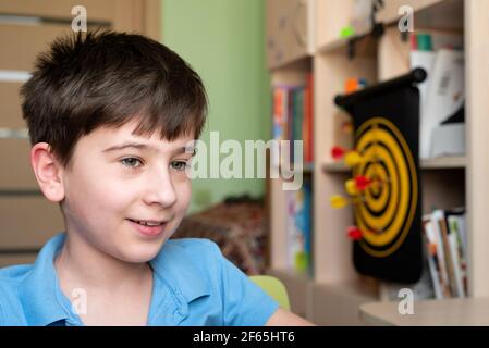Smiling boy using laptop at home. On-line or e-learning education on quarantine. Soft focus Stock Photo