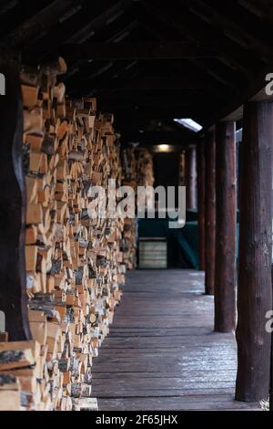 firewood in the woodpile. prepared fuel for kindling the stove in a country house. background texture of felled trees Stock Photo