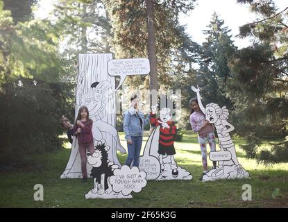 Children having fun with a giant 3D comic strip of the Beano, during the Easter festival at Kew Gardens in south-west London. This year's festival celebrates 70 years of Dennis the Menace with a series of activities and an interactive story trail around the gardens. Picture date: Tuesday March 30, 2021. Stock Photo