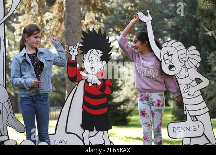 Children having fun with a giant 3D comic strip of the Beano, during the Easter festival at Kew Gardens in south-west London. This year's festival celebrates 70 years of Dennis the Menace with a series of activities and an interactive story trail around the gardens. Picture date: Tuesday March 30, 2021. Stock Photo