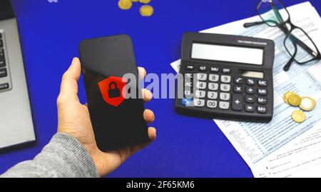 Data protection concept workspace, man holds smartphone with lock, cybersecurity background photo Stock Photo
