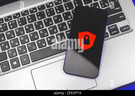 Digital cybersecurity and network protection concept with laptop and smartphone, red lock on screen Stock Photo