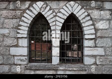 A mullioned window with pointed arches in a medieval stone building (Marche, Italy, Europe) Stock Photo