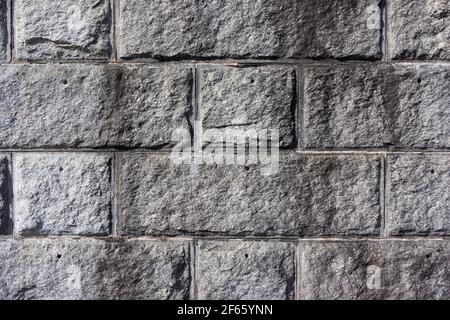 Large hewn granite stones of a defensive wall with joints between the stone in the early morning light. Stock Photo
