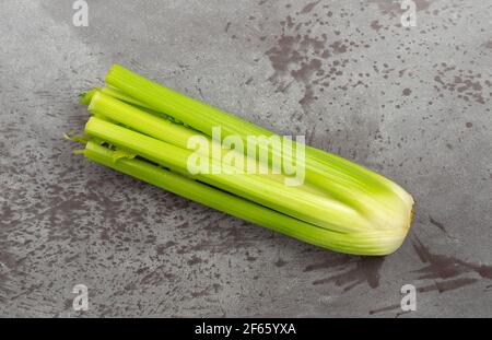 Top view of a fresh bunch of organic celery on a gray mottled background. Stock Photo