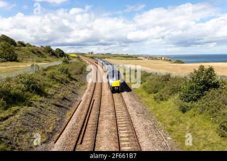 County Durham UK: 26th July 2020: Durham Heritage Coast East Coast mainline train passing by the sea on summer day Stock Photo