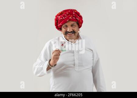 AN ADULT MAN WITH TURBAN HAPPILY SHOWING VOTER ID CARD Stock Photo