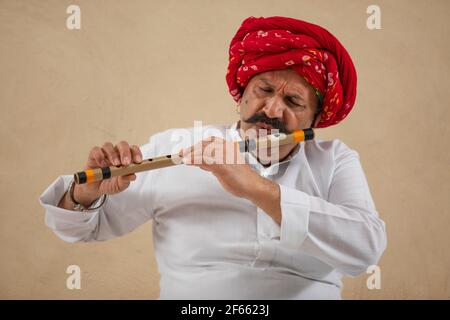 A RURAL TURBANED MAN PLAYING FLUTE Stock Photo