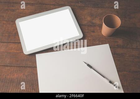 Modern office workplace with tablet pc on the table. On the table there is a tablet and a white sheet of paper with a pen. For a design presentation o Stock Photo