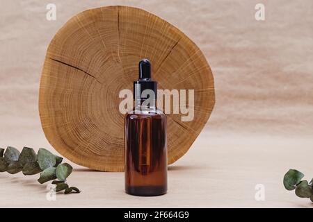 Bottle with face serum and wooden saw cut Stock Photo