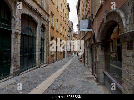 A narrow cobbled street between high, colourful old buildings in Vieux Lyon, France. Stock Photo