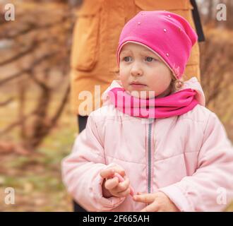 Portrait of a girl. Little girl in warm clothes on the street. Stock Photo