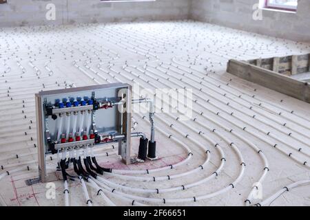 underfloor heating system - water pipes with collector on the new building floor Stock Photo