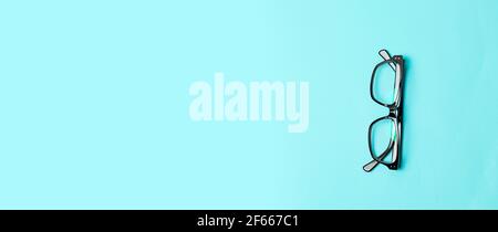 Glasses with transparent lenses on blue background top view copy space Stock Photo