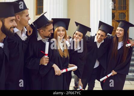 Happy students with diplomas after graduation ceremony outdoors Stock ...