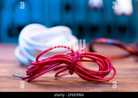 Red electrical cable close-up on the electrician's desk. Stock Photo