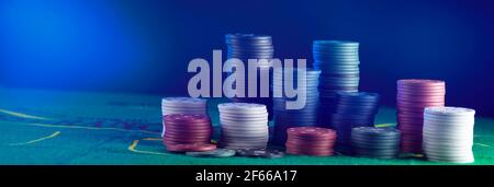 Many multi-colored poker chips on the gaming table. Stock Photo