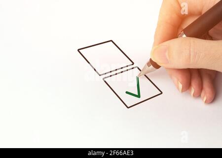 Male Hand Drawing Tick in Check Box. Cropped image of hand writing on checklist Stock Photo
