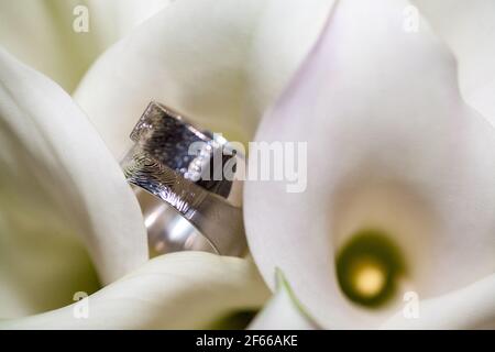 Close view on calla flowers with wedding rings in warm colors. High quality photo Stock Photo