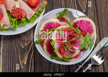 Salad with spinach, arugula radish, onion and cherry tomatoes. Bacon sandwich. On a brown background. Copy space. Stock Photo