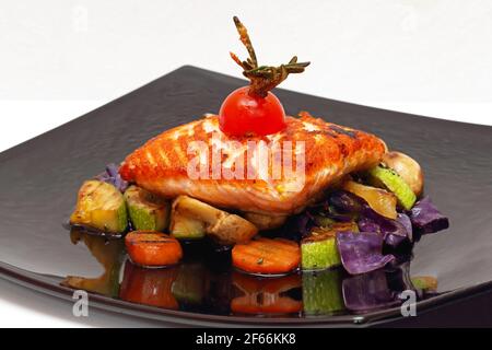 Grilled Salmon Fillet Served on Mixed Vegetables Stock Photo