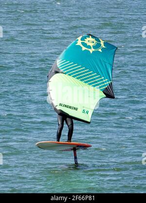 A man sailing on the Columbia River in the Columbia River Gorge near Hood River, Oregon, on a Wing Foil, or Sling Wing, or Slingshot, board. Stock Photo