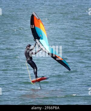 A man sailing on the Columbia River in the Columbia River Gorge near Hood River, Oregon, on a Wing Foil, or Sling Wing, or Slingshot, board. Stock Photo