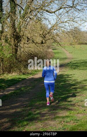 A middle aged woman taking exercise. A woman running. Stock Photo