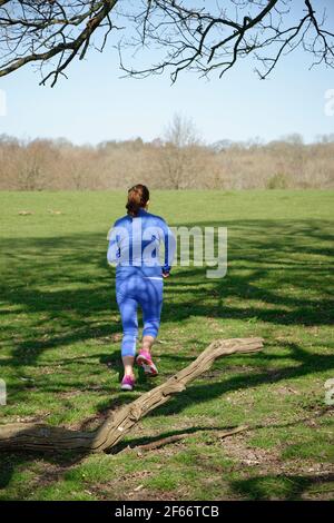 A middle aged woman taking exercise. A woman running. Stock Photo
