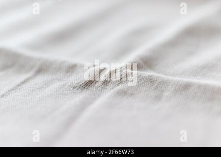 Soft light gray natural linen texture with focus on the fold. Crumpled fabric background. Selective focus. Closeup view Stock Photo