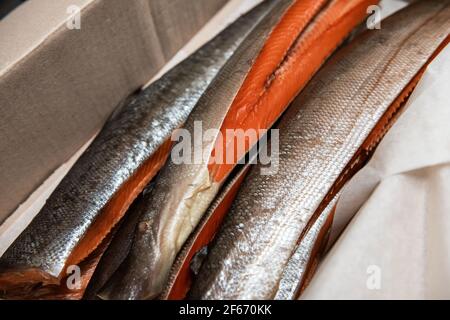 Smoked fish in craft paper box. Ready for delivery production. Smoked fish production concept Stock Photo
