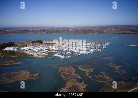 Northney Marina with moored yachts and boats on the pontoons situated on shore of Hayling Island in the beautiful Langstone Harbour., aerial view. Stock Photo