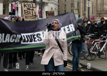 Kill the Bill protest Manchester, UK during the national lockdown in England. Demonstrator with microphone in front of Black Live Matter banner