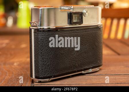 Back side of an old Kodak analog camera in silver with leather case and flash Stock Photo