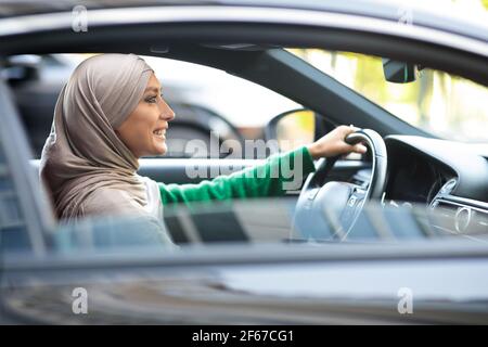 Cheerful muslim woman driving her new car Stock Photo