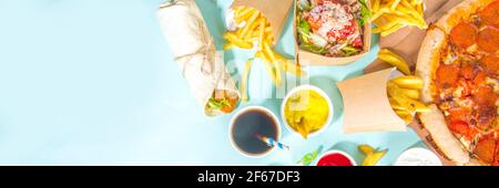 Delivery fastfood ordering food online concept. Large set assorted takeout foods pizza, french fries,  chicken nuggets, burgers, salads, chicken wings Stock Photo